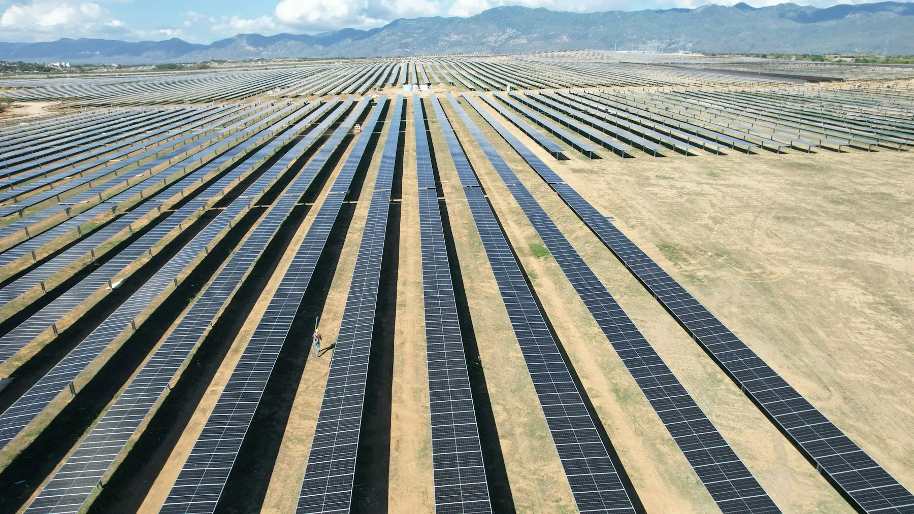 Aerial view of a utility-scale photovoltaic solar farm with rows of solar panels — Entogo grid-connection and PV box-substation customer environment
